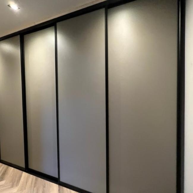 Moderne schuifwandkast met grijze panelen en zwart profiel