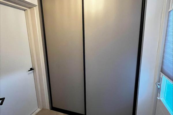 Steengrijze schuifkast met zwarte accenten